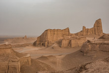 Man Standing On Viewpoint Overlooking Rugged Desert Landscape, Kalut, Iran