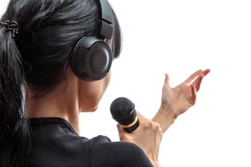 wireless headphones are on the head of a young girl brunettes with long hair with microphone in hand