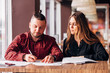 © newagecinema - young entrepreneurs made a deal in a cafe, signing documents