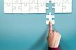 Complete Concept. Hand Replace a Final Jigsaw Puzzle Piece into a Last Blank. Symbolic of Teamwork and Business Success