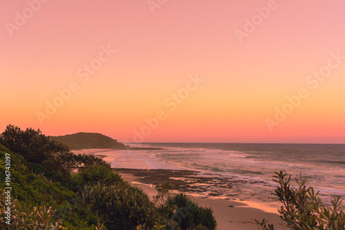 Fotomural The Pinky sunset in summer time on the beach in Ballina with ocean view and hill