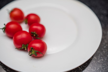 Cherry tomatoes on white plate closeup.