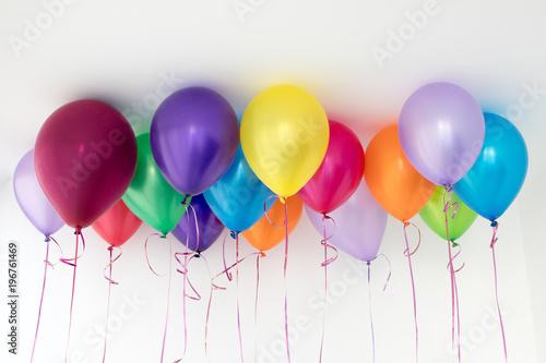 Bright Different Colored Helium Balloons Hanging Under White