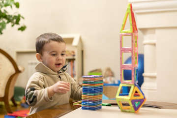The child plays with a magnetic constructor