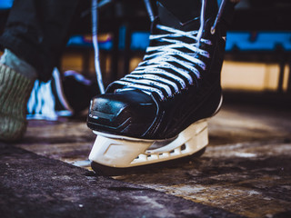 Wall Mural - close up shot of hand tie shoelaces of ice hockey skates in locker room