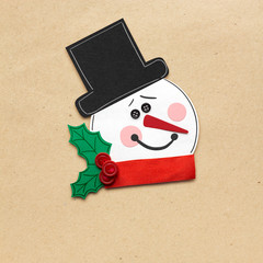 Wall Mural - Merry christmas / Creative photo of a snowman mad of paper on brown background.