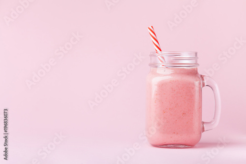 Fotografía Strawberry smoothie or milkshake in mason jar on pink pastel background
