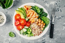Buddha Bowl With Spinach Salad, Quinoa, Roasted Chickpeas, Grilled Chicken, Avocado, Tomatoes, Cucumbers, Sesame Seeds.