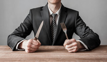 Businessman Holding Fork With Knife And Ready To Eat. Concept Of Competition In Business