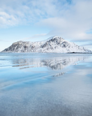 Wall Mural - Mountain ridge and reflection on the seashore. Natural landscape in the Norway