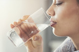 Fototapeta Łazienka - Young woman drinking pure glass of water