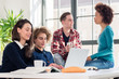 © Kzenon - Four young students watching together a funny online video on a laptop during break in the classroom of a modern college or university