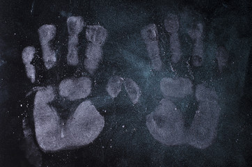 white prints of hands on a black background