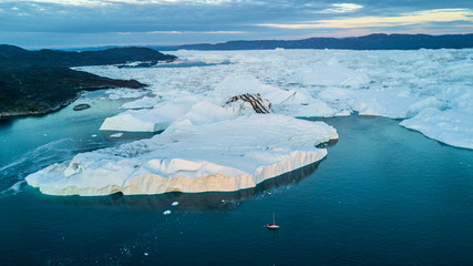 Wall Mural - yacht and largest icebergs field. classic greenland drone view