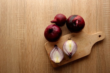 Wall Mural - Organic red onion on wooden table, copy space for your design