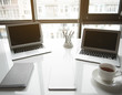 © Yakobchuk Olena - Two screens of notebook computer, cup of tea and copybook situating on white table in apartment. Modern office concept. Close up