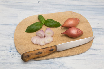 knife wooden board old and shallot basil