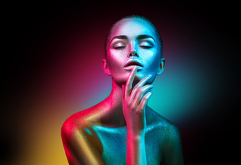 Wall Mural - Fashion model woman in colorful bright sparkles and neon lights posing in studio, portrait of beautiful sexy girl. Art design colorful vivid makeup