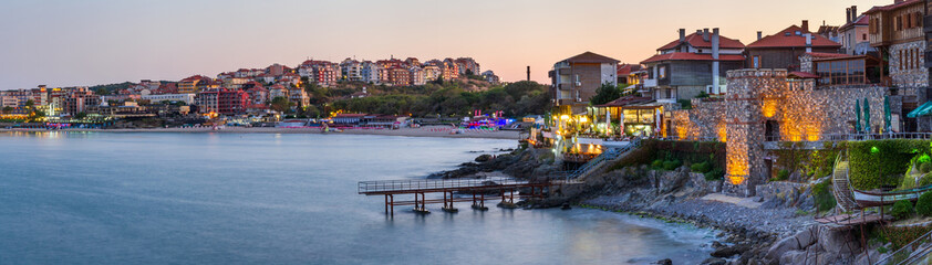 Wall Mural - Seaside landscape, panorama, banner - view of the embankment with fortress wall during sunset in the city of Sozopol on the Black Sea coast in Bulgaria.