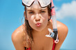 © WHstudio Leushin N - Attractive woman wears snorkel scuba mask, roundes lips, swims in ocean or sea, likes diving, enjoys summer holidays, poses against blue sky background. People, water sport and recreation concept