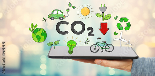 Fotografie, Obraz Reduce CO2 with man holding a tablet computer