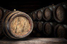 Wine Barrel On The Old Wooden Table. Wine Cellar At The Background.