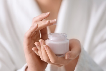 Wall Mural - Young woman with jar of hand cream, closeup