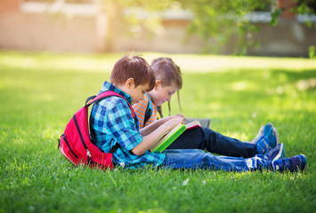 Wall Mural - Children with rucksacks standing in the park near school. Pupils with books and backpacks outdoors