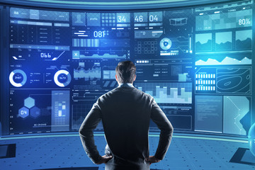calm specialist. concentrated smart experienced programmer standing with his hands on the hips and l