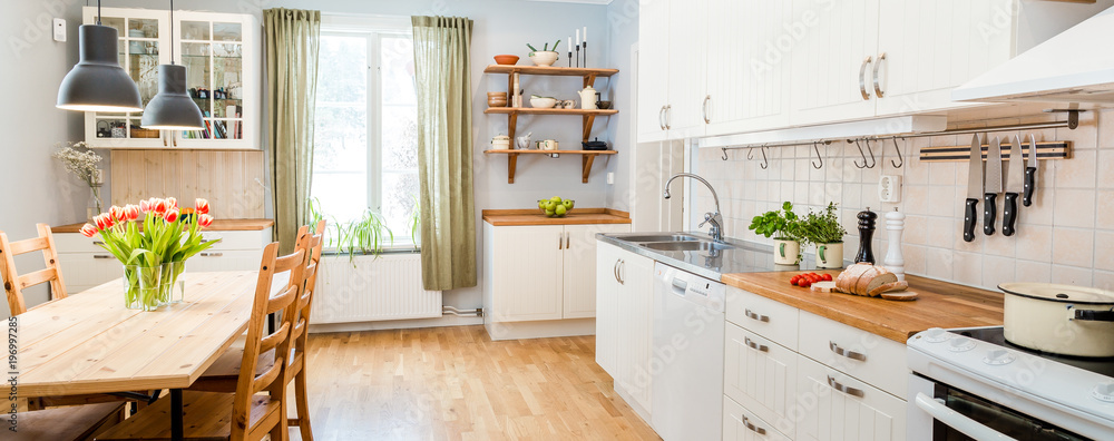 banner of a kitchen with kitchen table  and breakfast at the kitchen counter top white cupboards and wooden floor - obrazy, fototapety, plakaty 