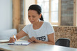 © zinkevych - Paper work. Focused attentive female volunteer sitting at table while writing document and looking down