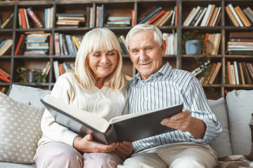 Wall Mural - Senior couple together at home retirement concept photograph album front view