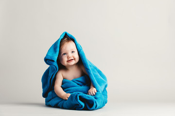 baby girl covered with a blue warm blanket