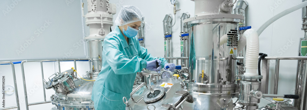 Pharmaceutical factory woman worker in protective clothing operating production line in sterile environment - obrazy, fototapety, plakaty 