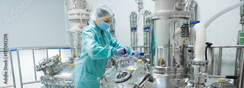 Fotografía Pharmaceutical factory woman worker in protective clothing operating production