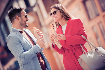 Wall Mural - Young couple in love,eating sandwich after shopping