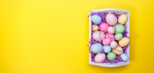 Wall Mural - Multicolor eggs in a white tray. Creative Easter concept. Modern solid yellow background.