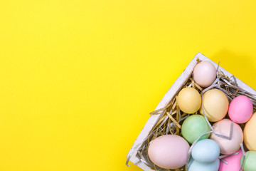 Wall Mural - Multicolor eggs in a white tray. Creative Easter concept. Modern solid yellow background.