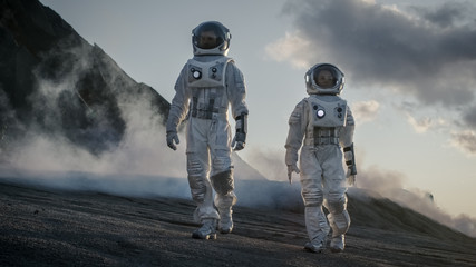 two astronauts in space suits confidently walking on alien planet, exploration of the the planet's s