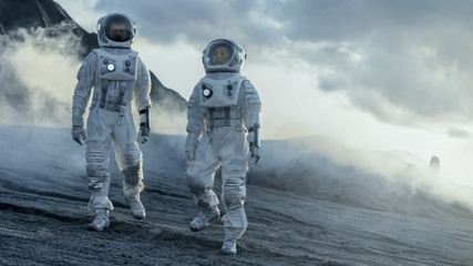 Wall Mural - two astronauts explore rocky alien planet in the day time. near future and technological advance bri