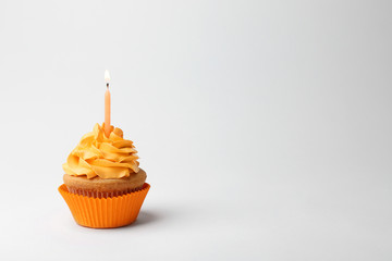 Birthday cupcake with candle on white background