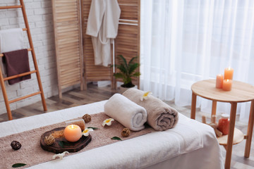 Wall Mural - Massage table with towels, candle and sea salt in spa salon