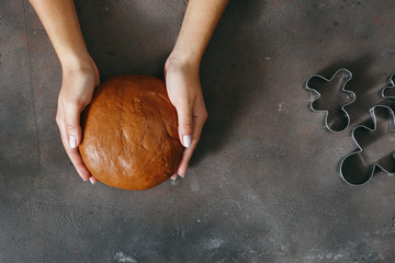 Sticker - Women's hands holding fresh dough for cooking Christmas gingerbread cookies top view