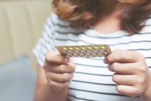 Woman Hands Opening Birth Control Pills In Hand. Eating Contraceptive Pill.	