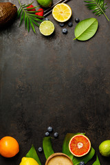 Cocktail making bar tools, tropical fruits and leaves on a dark