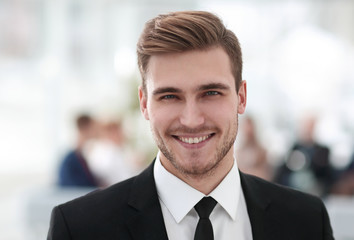 Poster - portrait of confident young businessman on blurred background.