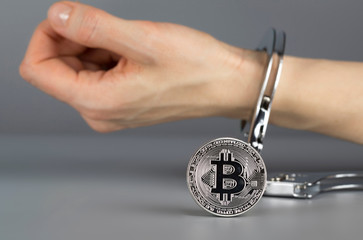 Wall Mural - Bitcoin in front of hand in handcuff.