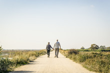 Elderly Couple In Love Walking On A Dust Road, Portugal