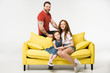 © LIGHTFIELD STUDIOS - Happy family sitting on couch isolated on white