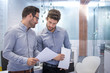 © Bojan - Two handsome bearded business men discussing paperwork in office